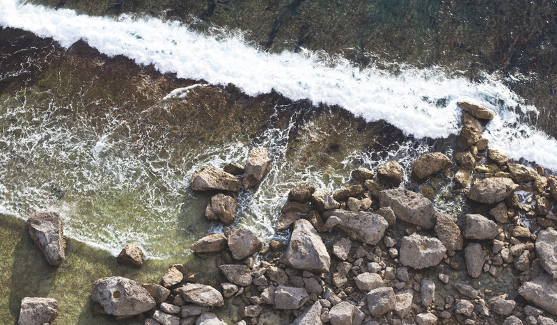 guam, flowing water, rocks, wave, stone, aquatic sport, beauty in nature, ocean, no people, high angle view, motion, flowing, outdoors, two lovers point