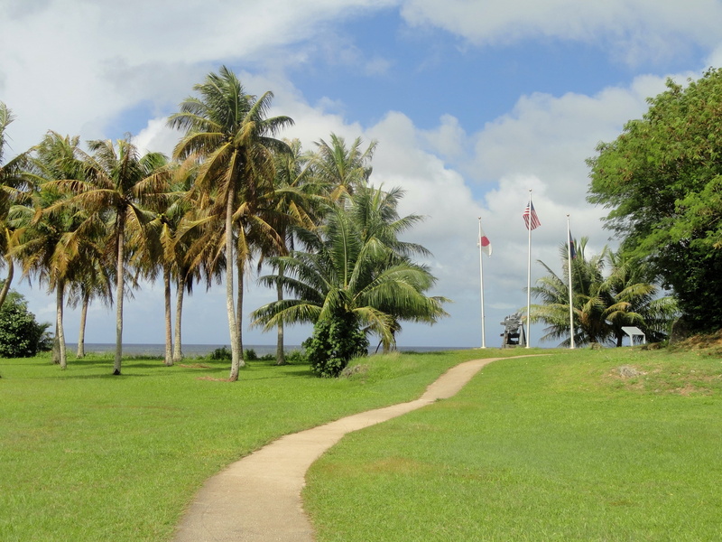 field, outdoors, countryside, grass, tranquility, flags, water, mountains, cloud - sky, landscape, land, ocean, no people, greenery, sea, day, tropical