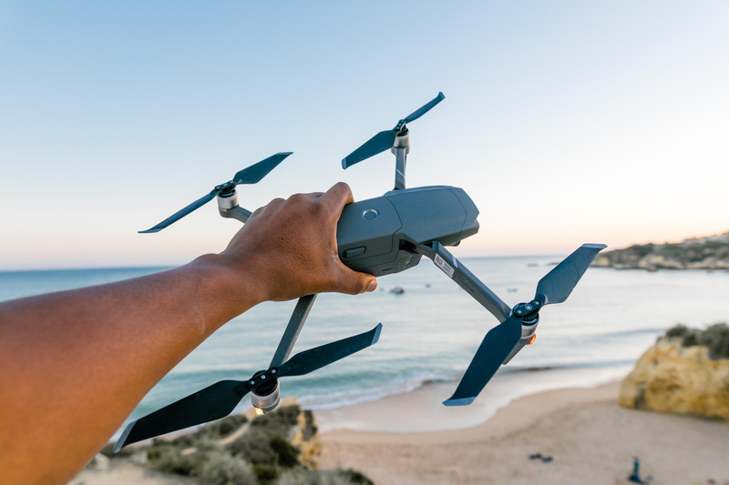 clear sky, ocean, vacation, hand, men, one person, recreation, daylight, sea, leisure activity, water, model, holding, black, summer, seashore, quadcopter