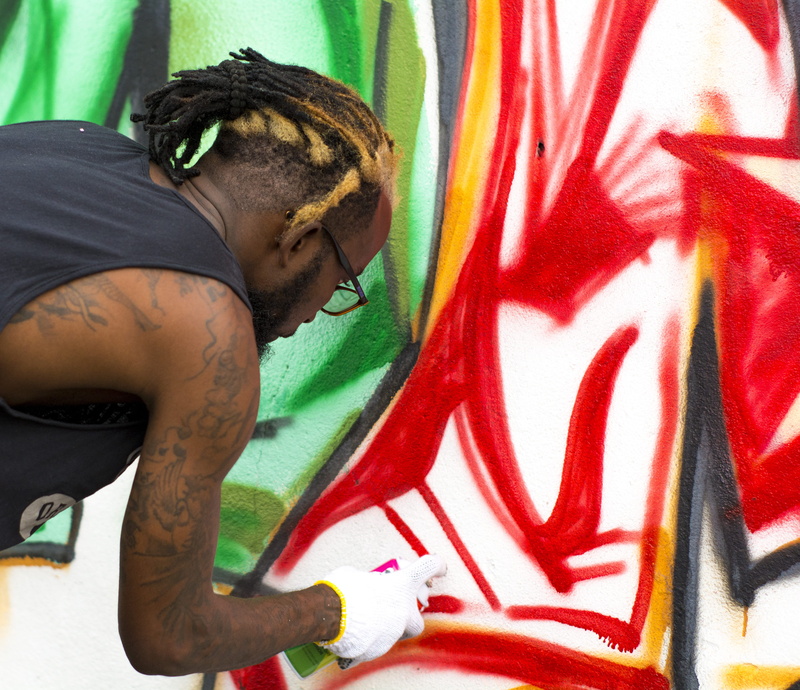 africa, graffiti, the artist, young adult, wall, day, waist up, art, paint container, skin, creativity, art and craft, people, mural, artist, person, real people