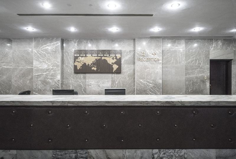desk, empty, reception desk, seat, floor, pyongyang, lighting equipment, ceiling, waiting room, wall - building feature, stage, no people, table, electric light