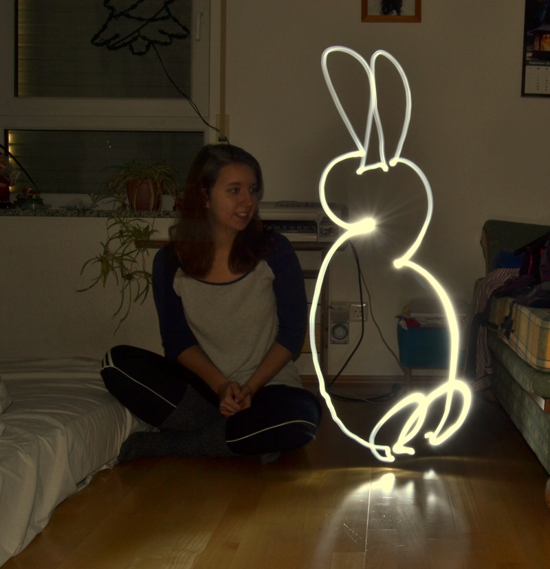 light painting, sitting, communication, 1080P, glowing, lightpainting, night, light, one person, leisure activity, front view, real people, illuminated