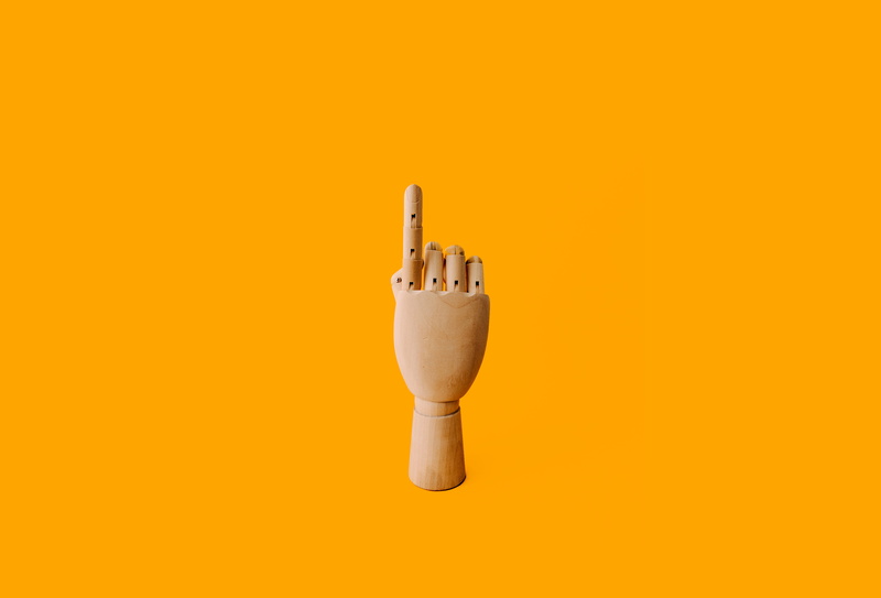 indoors, pointing, orange color, manikin, sculpture, point, no people, studio shot, electricity, rubber, technology, pencil, wooden, close-up, simplicity