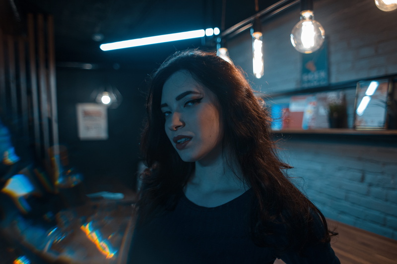 indoors, headshot, long hair, club, looking, night club, electronics, hairstyle, contemplation, monitor, young adult, lamps, lightbulb, dark, light, focus on foreground