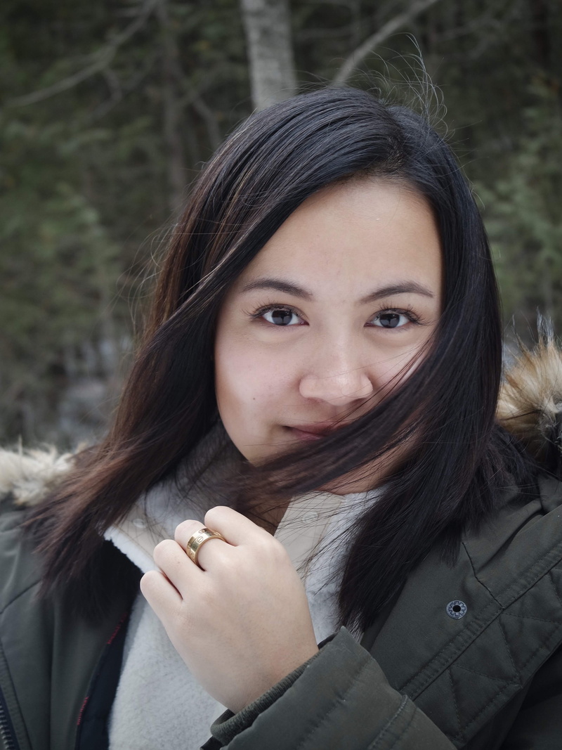 clothing, focus on foreground, lifestyles, overcoat, outdoors, face, women, winter, long hair, wheel, person, pants, mouth, mammal, apparel, headshot, nail