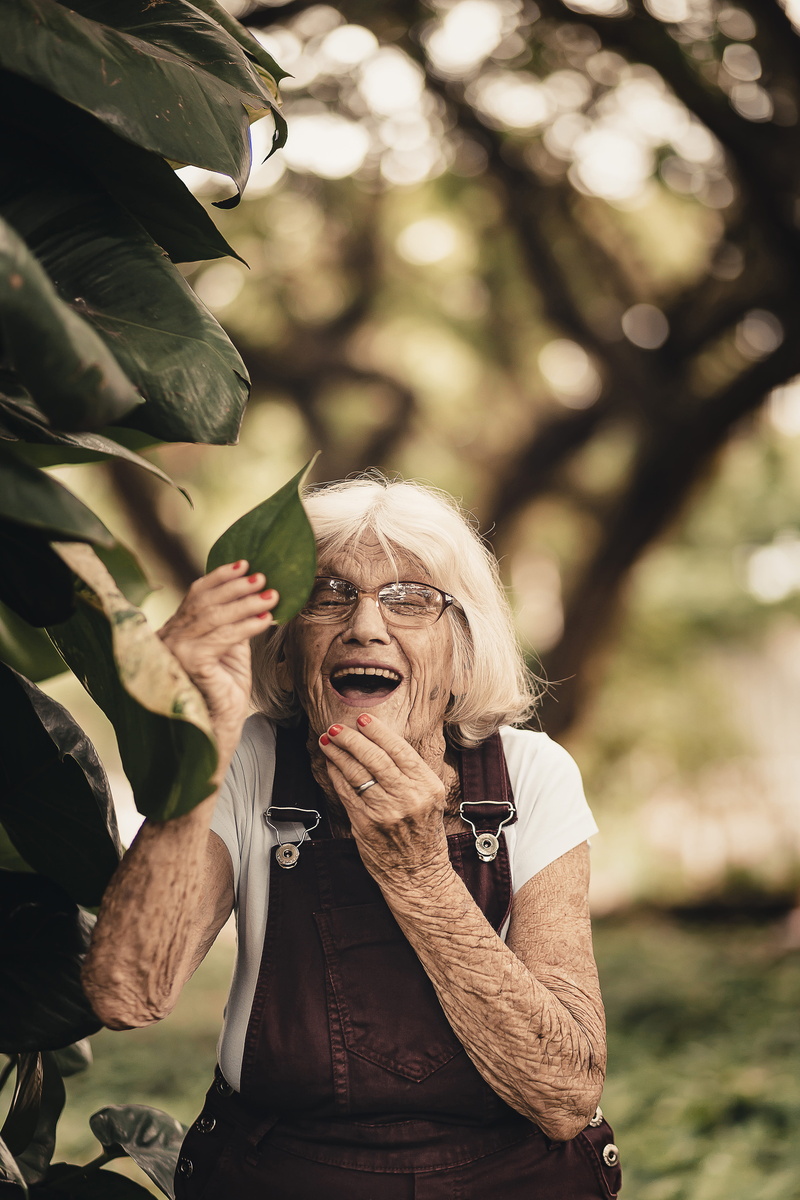 looking at camera, wrinkled, tree, white hair, casual clothing, eyewear, cute, holding, one person, adult, happiness, gray hair, 5K, green, woman, focus on foreground