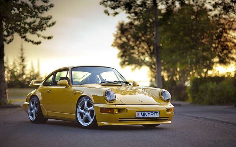no people, motor vehicle, road, nature, yellow, land vehicle, sunlight, day, coupe, tree, outdoors, retro styled, Porsche, car, mode of transportation
