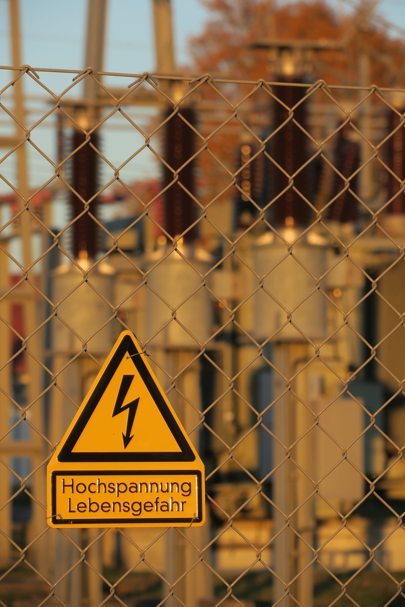 text, sign, fence, warning, chainlink fence, dangerous, focus on foreground, shield, protection, western script, 5K, voltage, triangle shape, caution