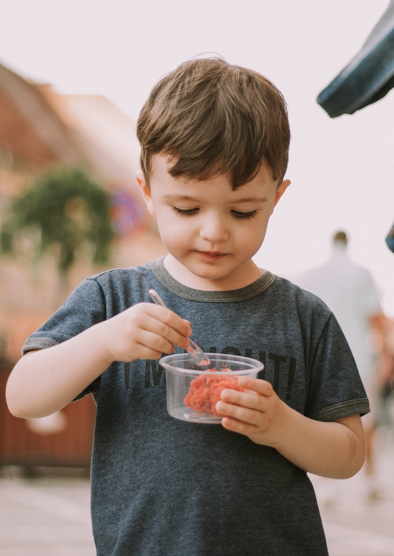 t, looking down, focus on foreground, waist up, child, boy, cute, 4K, one Person, one boy only, real people, eat, time, indoors, t-shirt, food And Drink