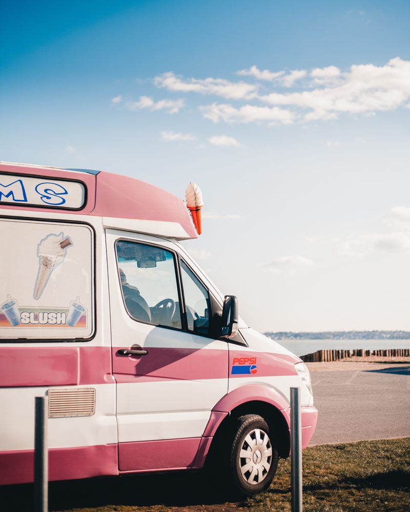 car wheel, tire, transportation, red, travel, cloud - sky, outdoors, vehicle, van, caravan, communication, trademark, minibus, machine, city, person, logo