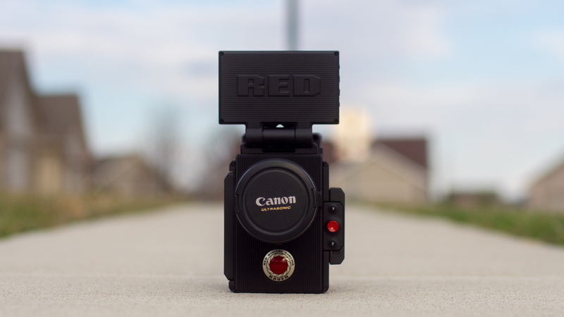 electronics, street, black, red, black color, filmmaker, day, side walk, daytime, film, camera, city, focus on foreground, cinema, lens cap, 4K, western script