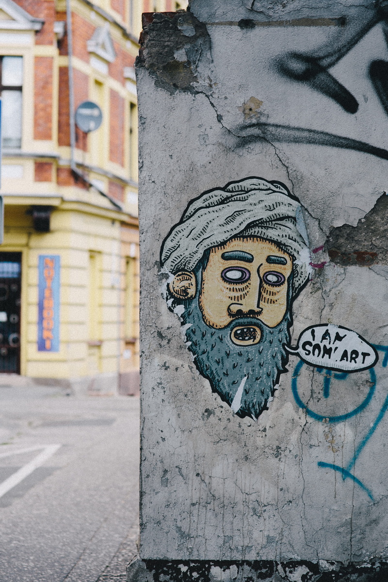craft, human representation, outdoors, communication, street art, wall, Muslim, bin laden, city, bin, mural, art and craft, building exterior, day, creativity