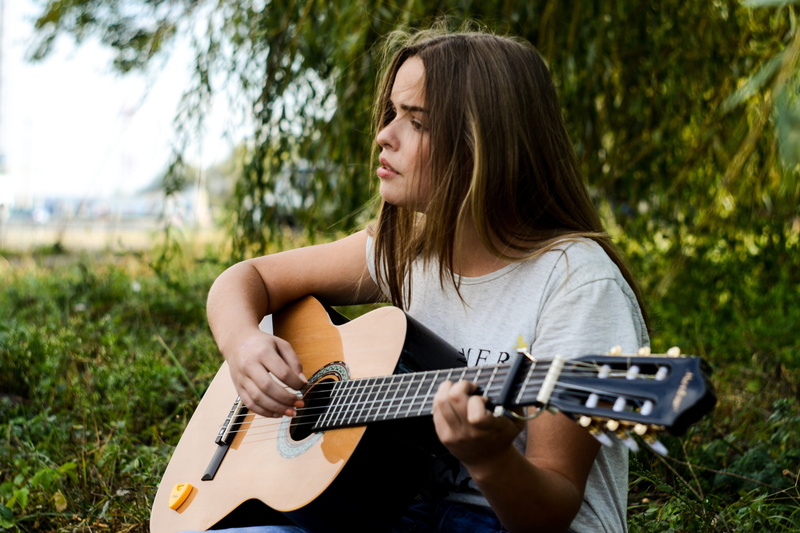 woman, outdoors, musician, women, adult, artist, guitar, one person, playing, leisure activity, plucking an instrument, guitarist, hairstyle, day, white