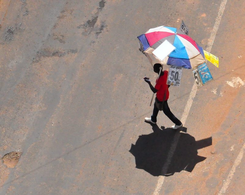 full length, walking, sunlight, streets, holding, protection, yaounde, streetfighter, standing, rain, communications, shadow, cameroon, telco, streetphotography