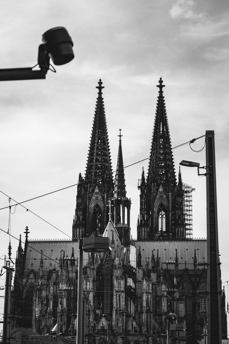 sky, architecture, spire, low angle view, place of worship, travel destinations, built structure, kölner dom, religion, church, street, no people, street light