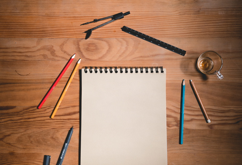 sketch, pen, no people, indoors, table, directly above, pencil, book, wood grain, hand saw, spiral notebook, still life, furniture, pens, desk, blank, writing instrument