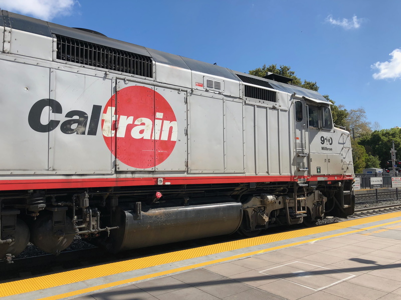 train track, machine, sign, red, travel, motor, land vehicle, 295 w evelyn ave, steam engine, shipping container, outdoors, terminal, day, mode of transportation