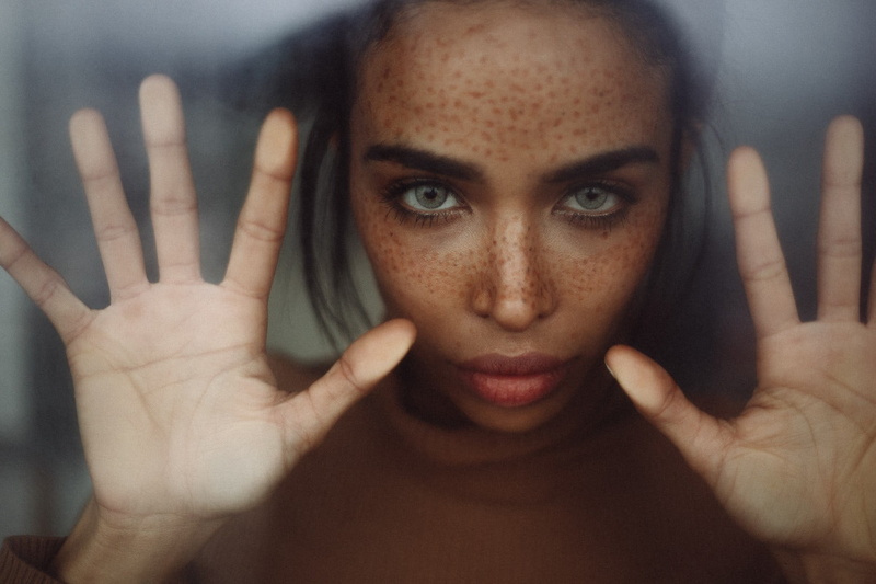 human body part, portrait, indoors, human face, adult, young women, focus on foreground, gesturing, glass, one person, close-up, women, hand raised, looking at camera