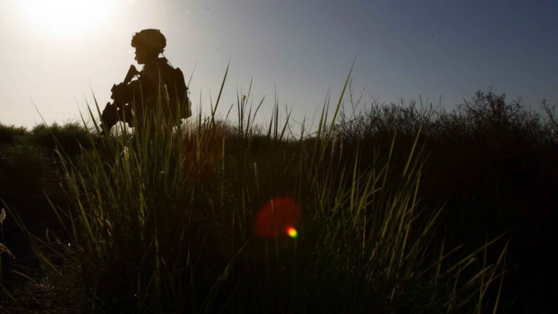 one person, sunset, leisure activity, military, three quarter length, land, sky, sunlight, lifestyles, weapon, table, real people, tranquility, grass, plant
