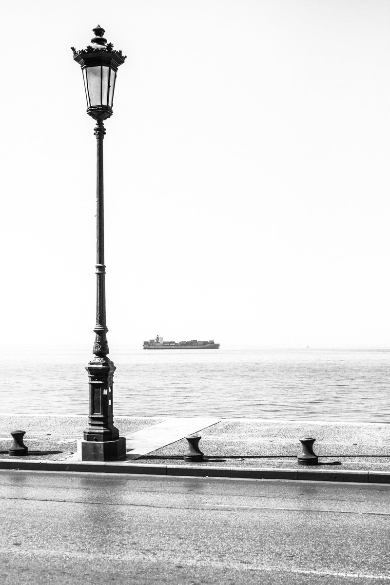 horizon over water, street, ocean, street lamp, water, sky, architecture, built structure, container ship, clear sky, street light, statue, building exterior