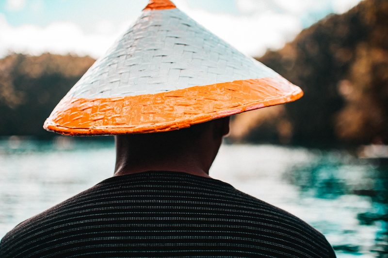 outdoors, text, crash helmet, triangle, cowboy hat, pinata, focus on foreground, one person, sun hat, real people, swimwear, nature, unrecognizable person