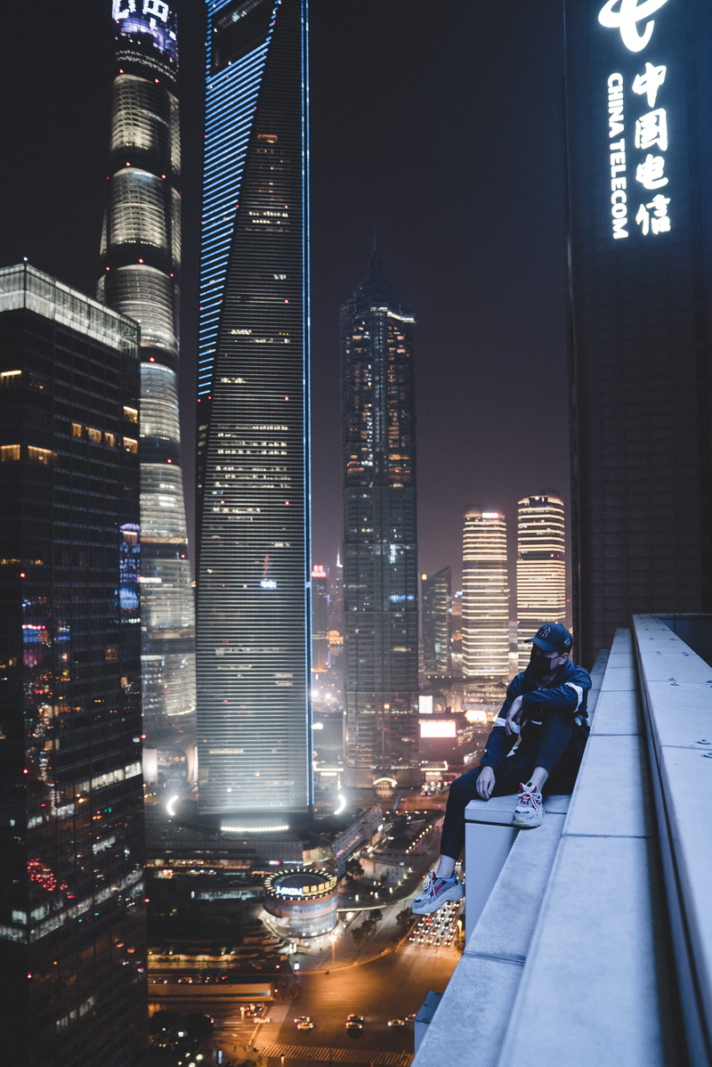 financial district, cityscape, nighttime, modern, outdoors, office, tall - high, man, skyscraper, building, transportation, fashion, thinking, city life
