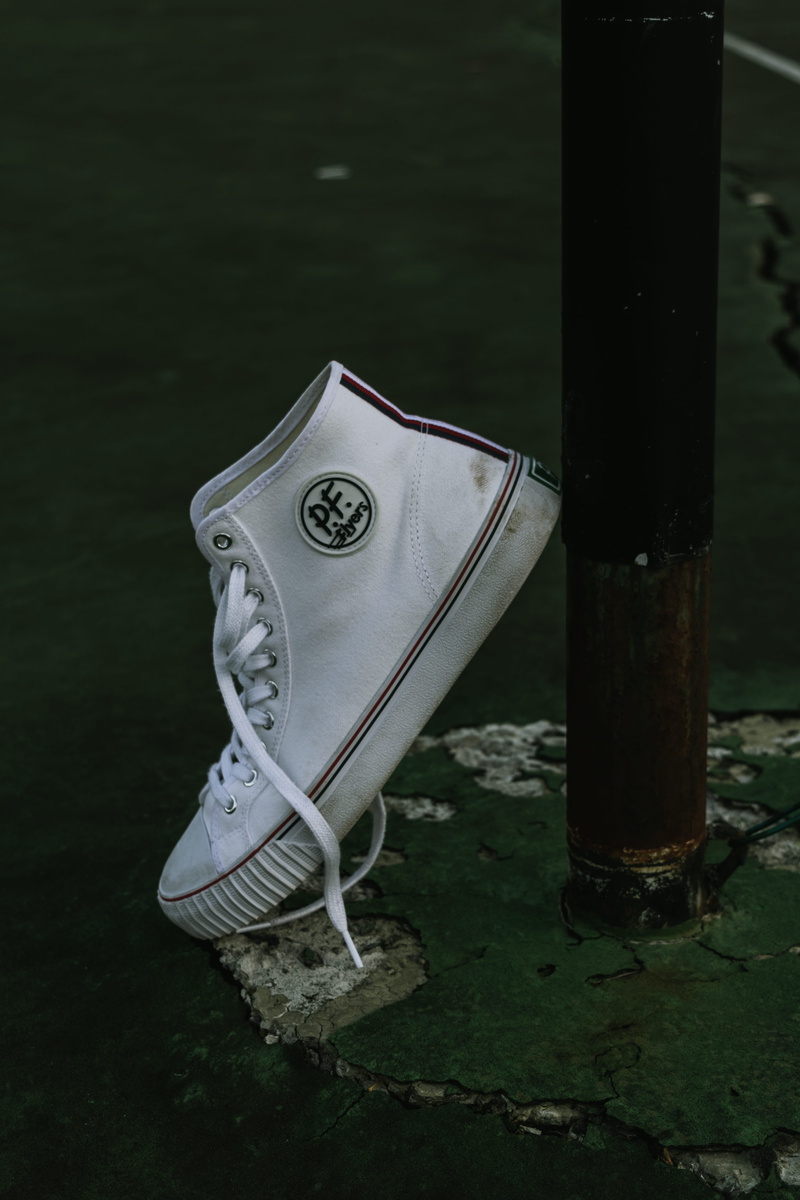 no people, pf flyer, focus on foreground, white, unpaired, pole, silver colored, dirt, old, field, still life, ground, product, wooden post, footwear, shoe