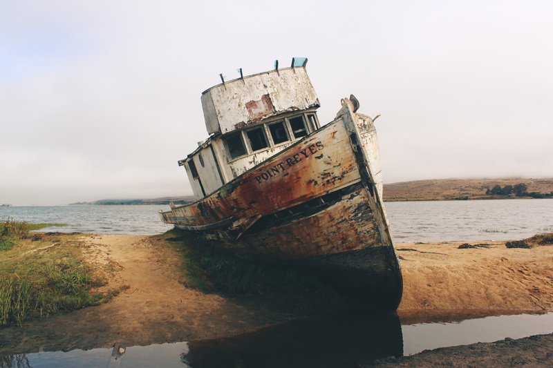 wreckage, outdoors, water, sunken, sinking, deterioration, daytime, strand, brown, old, derelict, rusty, land, sand, obsolete, decline, damaged, mode of transportation