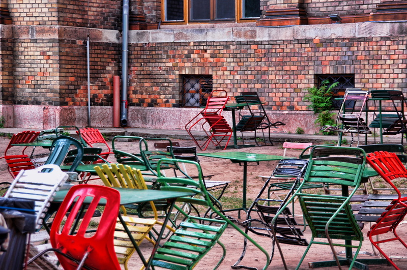 colorful chairs, outside catering, adult, wall, city, bicycle, people, transportation, brick, city park, architecture, day, street cafe, farbenspiel, mode of transportation