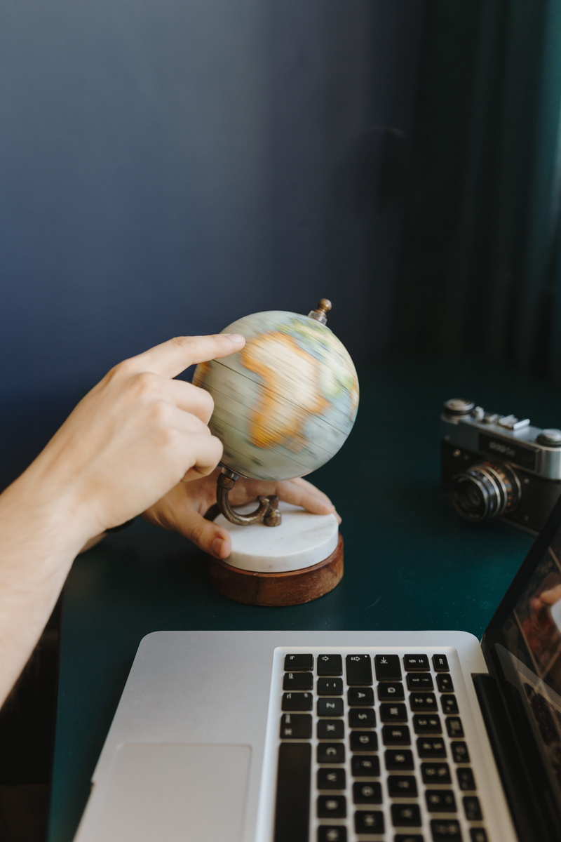 food, travel, hand, showing, food and drink, communication, one person, high angle view, using laptop, globe, table, adult, human hand, part, world, human body part