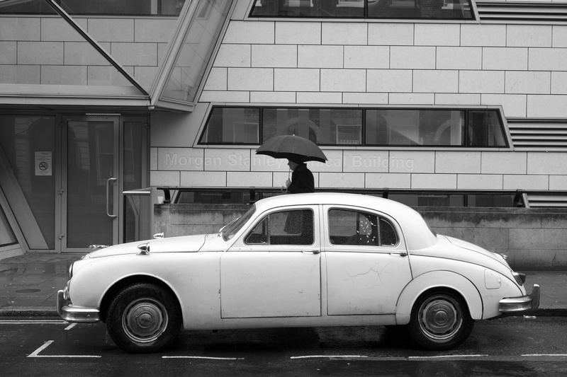 vintage, outdoors, classic car, street, wet, protection, parked car, stationary, holding, rain, transportation, black and white, motor vehicle, man, white