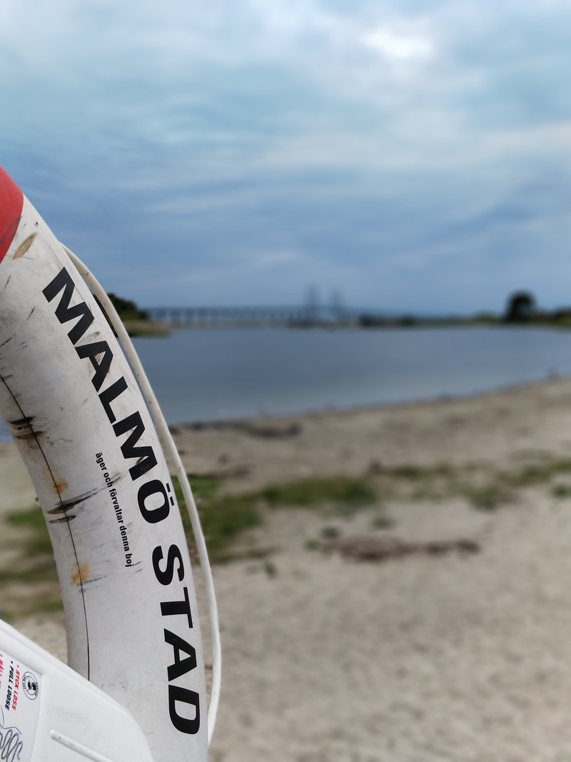 day, 4K, western script, outdoors, nature, focus on foreground, sea, water, malmö, beach, close-up, no people, communication, text, lifebelt, öresund