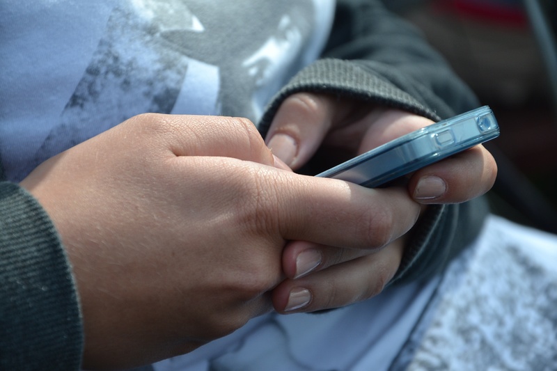 holding, using phone, communication, real people, electronics, mobile phone, hand, outdoors, lifestyles, to write, cellular phone, sms, apple, iphone, wireless technology