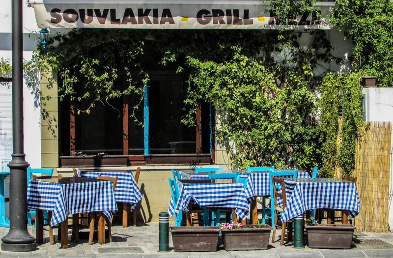 potted plant, larnaca, building, tavern, table, town, building exterior, green color, outdoors, plant, chair, built structure, greek food, absence, restaurant