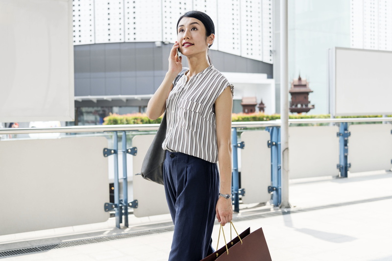 pinstriped, wireless, internet, outdoors, cellphone, wear, standing, buildings, using, young women, women, ethnicity, wearing, smiling, smartphone, person