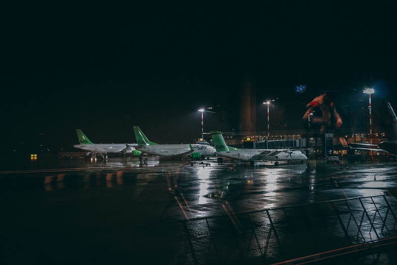 airplane, illuminated, plane, floodlight, built structure, nighttime, wet, barrier, fence, runway, lights, spotlight, mode of transportation, harbor, three