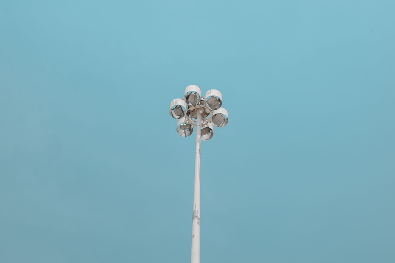 sky, tall - high, outdoors, low angle view, day, space, floodlight, lighting equipment, blue, white, pole, clear sky, high, bulb, copy space, stadium, post