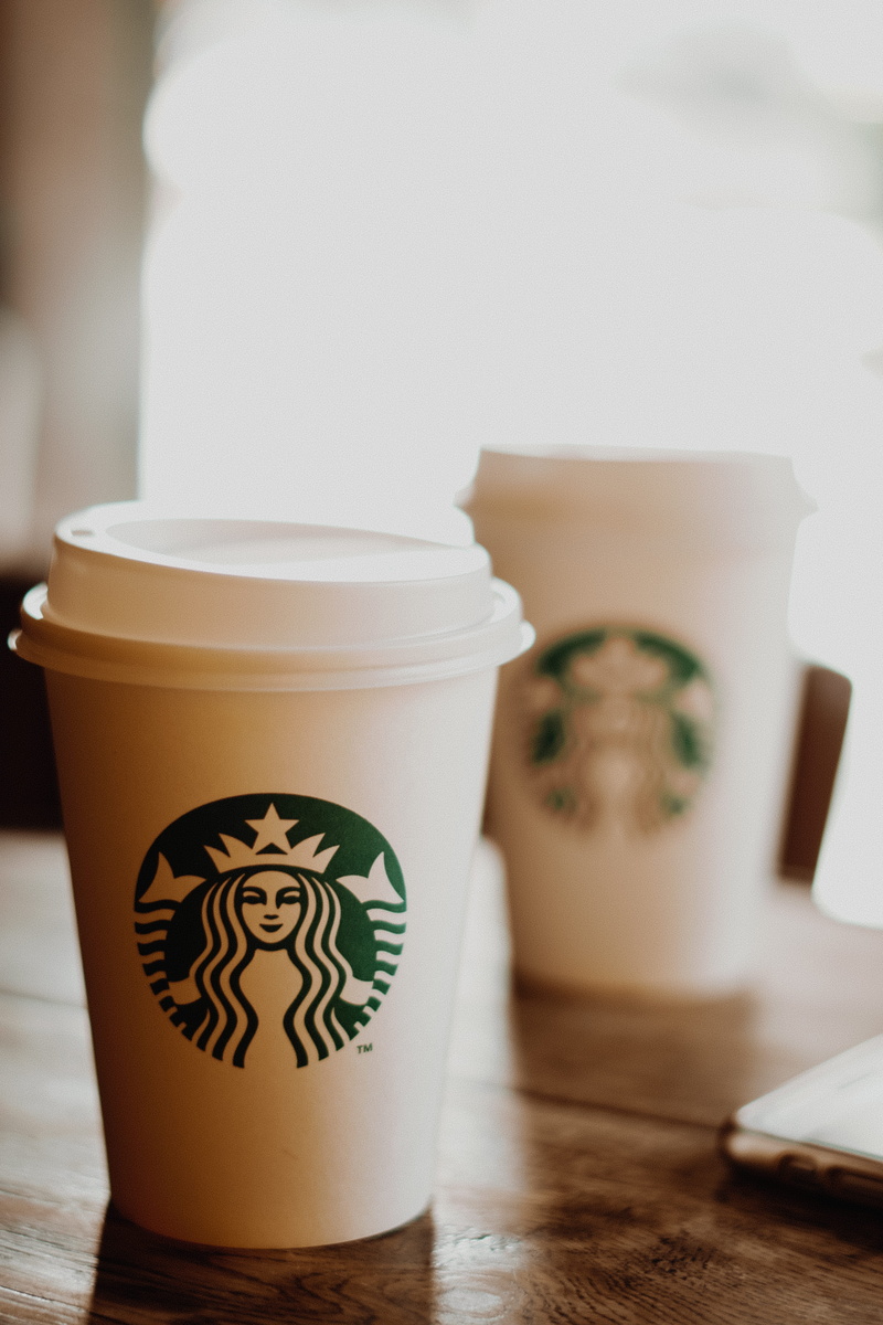 cup, group of objects, coffee, container, focus, depth of field, starbucks, close, lid, coffee cup, focus on foreground, drink, logo, close-up, table, paper cup