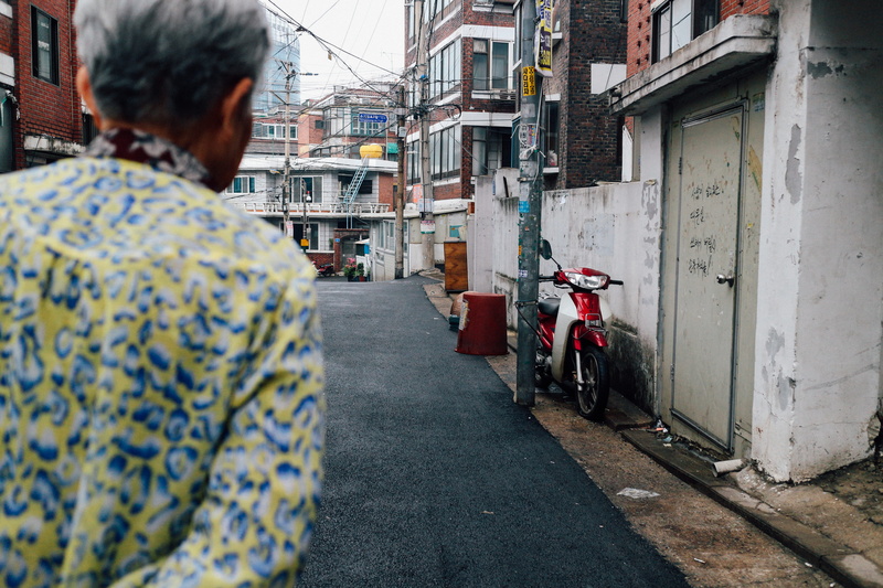 land vehicle, motorcycle, adult, street, transportation, building, the way forward, people, lifestyles, wall, daytime, graffiti, city, motor, road, red