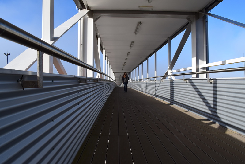 long, direction, outdoors, footbridge, metal, metal construction, transportation, sky, the way forward, connection, sunlight, shadow, ceiling, diminishing perspective