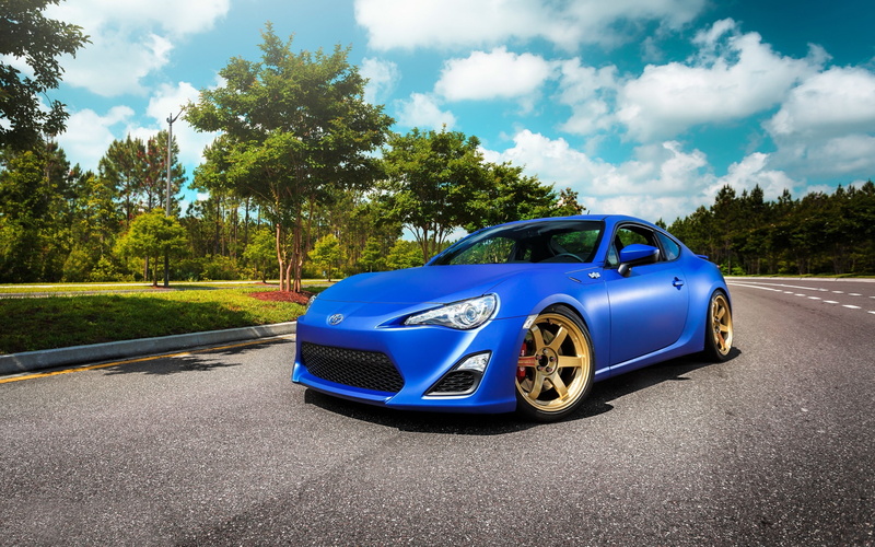 motor vehicle, asphalt, green color, mode of transportation, rims, plant, retro styled, nature, Toyota 86, outdoors, street, sky, car, 2K, no people, road