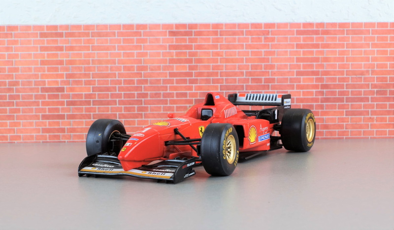 wall - building feature, wheel, fast, formula 1, auto racing, wall, toys, sports track, motor racing track, red, model car, model, f310, indoors, automotive