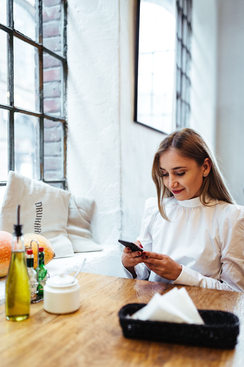 lifestyles, text Messaging, adult, restaurant, smiling, technology, table, wireless Technology, telephone, relaxation, communication, smart Phone, mobile Phone