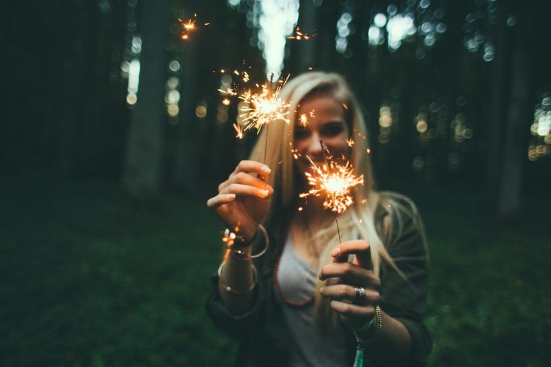 firework - man made object, burning, sparks, firework display, sweater, glowing, blonde, leisure activity, event, focus on foreground, front view, long exposure