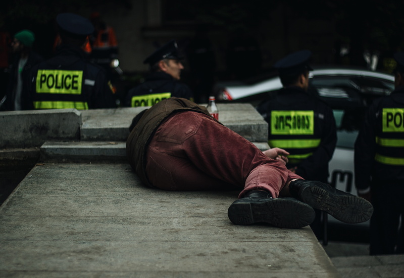 street, tarmac, officer, footwear, human, occupation, lying, clothing, government, people, safety, crash helmet, police force, military, island, city, person