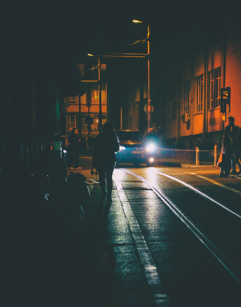 land vehicle, walking, building exterior, vehicle, nightime, pavement, road, architecture, night, city life, street, dark, built structure, transportation system