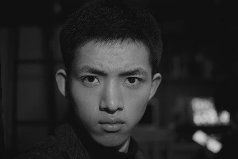 looking at camera, front view, human face, freckle, hair, close-up, selective focus, handsome, photography, smile, contemplation, jaw, dark, body part