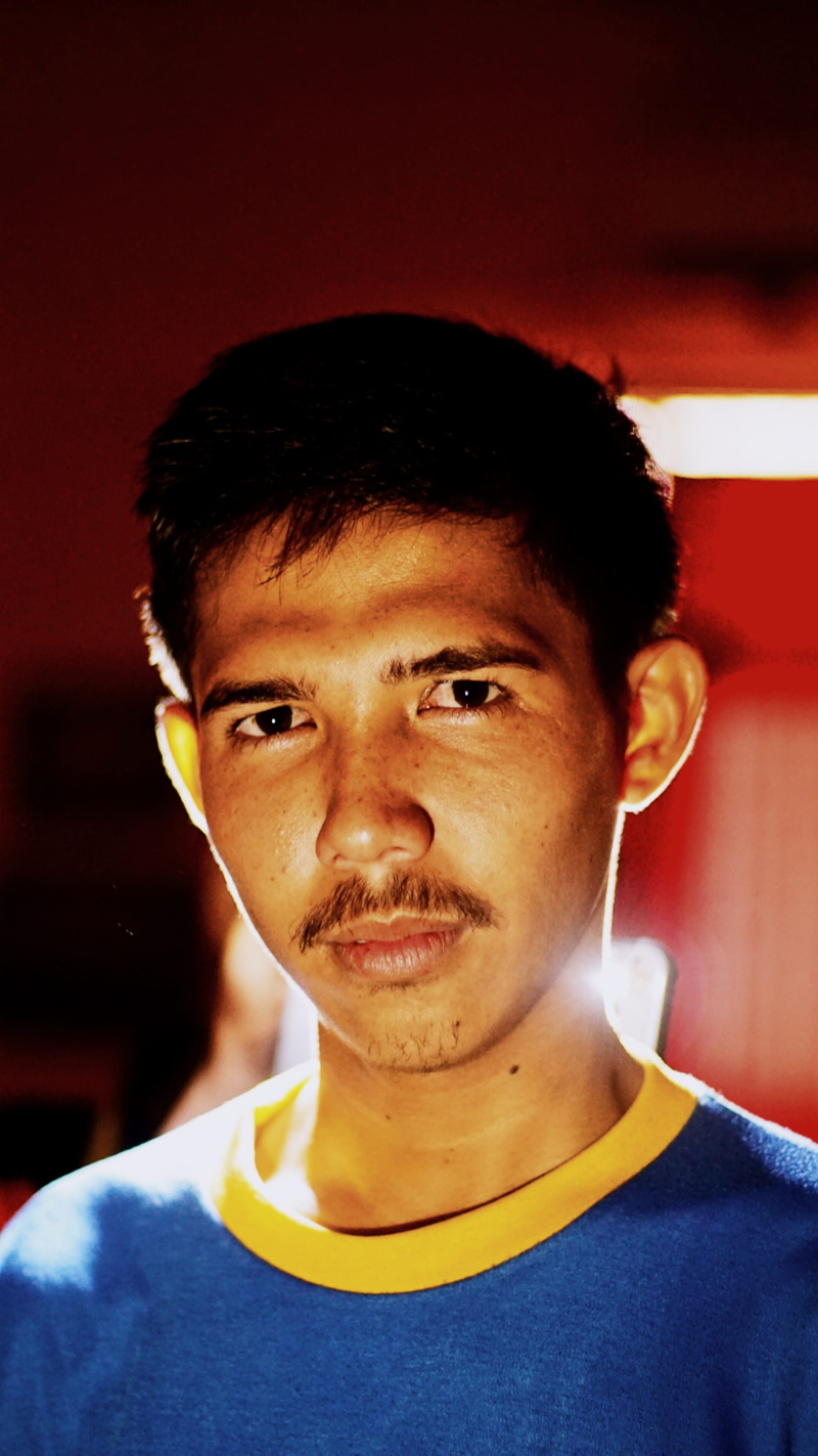 headshot, mouth, head, young adult, t-shirt, blue, young men, finger, person, photography, men, focus on foreground, lifestyles, clothing, front view, portrait