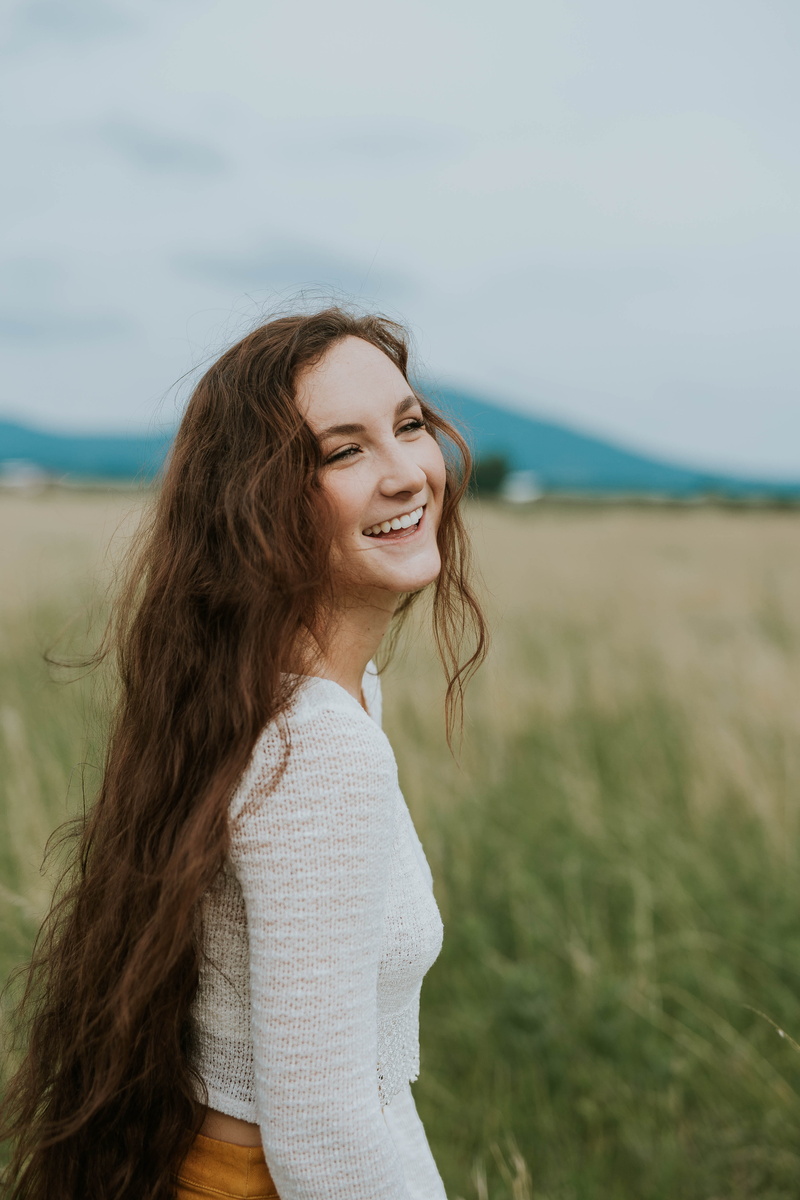 casual clothing, white, field, standing, daytime, brown Hair, smiling, portrait, sleeves, wearing, beauty, rural Scene, joy, one Person, 5K, long, only Women