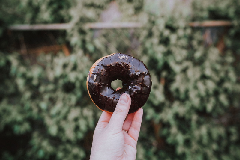one person, food, body part, finger, hand, lifestyles, real people, donut, unrecognizable person, outdoors, human body part, focus on foreground, human hand